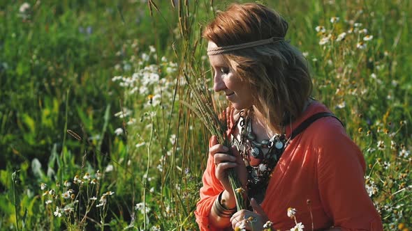 Portrait of Blonde Hippie Dancing in a Field with Flowers