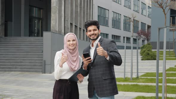 Smiling Woman in Hijab and Muslim Handsome Man Showing Thumbs Up While Standing