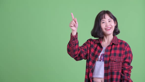 Happy Asian Hipster Woman Thinking While Pointing Up