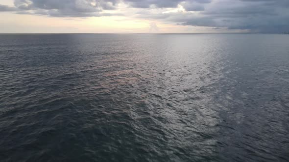 Aerial view of calm ocean with sunset background