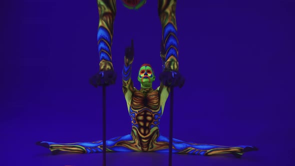 Acrobats In Neon Glowing Costumes Perform A One Arm Handstand. Ultraviolet. Alien Style