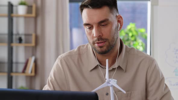 Male Teacher with Laptop and Wind Turbine at Home