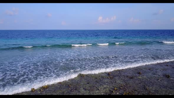 Aerial drone shot travel of luxury tourist beach adventure by aqua blue ocean and bright sandy backg