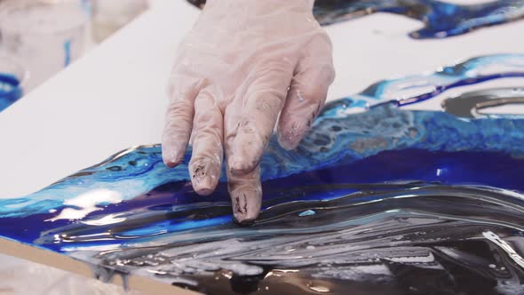 Smearing Dark Epoxy Resin on the Painting with a Finger