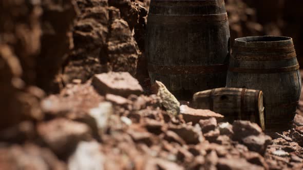 Old Wooden Vintage Wine Barrels Near Stone Wall in Canyon alt