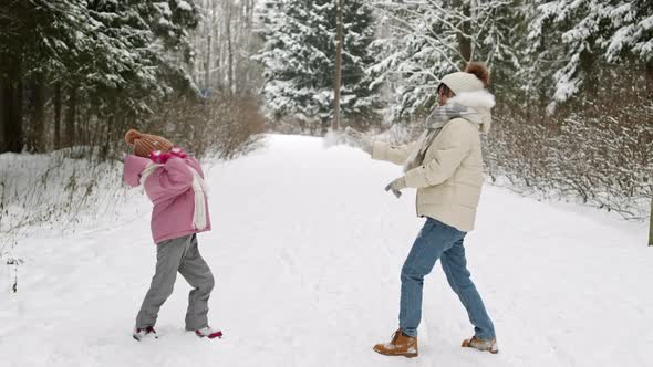 Mother and Kid Playing Snowballs