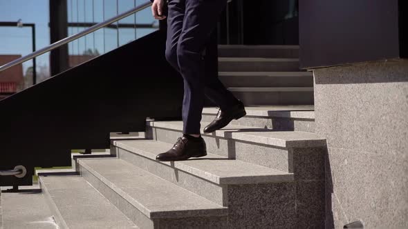 Man in Business Blue Suit Walks Down the Stairs Outside