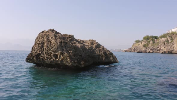 Big Rock Formation in Blue Wavy Sea Water