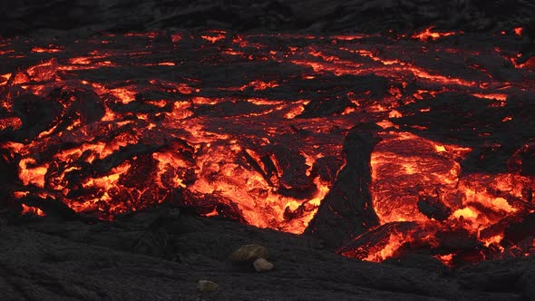 Primordial scenic landscape with fiery red lava river. Panning