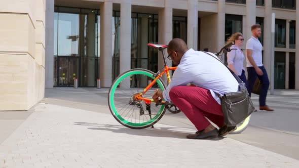 Afroamerican Businessman Fixing Bike After Cycling in Street