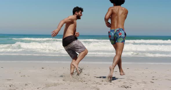 Young male friends running towards sea 4k