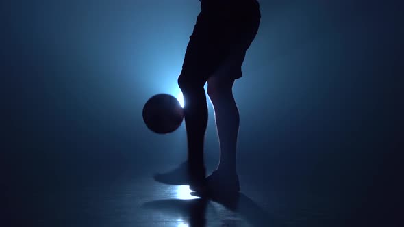 Feet of Football Player Are Stuffing the Ball in Twilight.