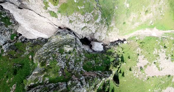 Top View of Steep Mountain Cliffs and an Ice Cave