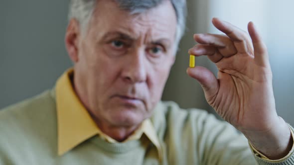 Unhealthy Old Senior Retired Male Caucasian Sick Ill Patient 60s Grandfather Man Holds Pill with