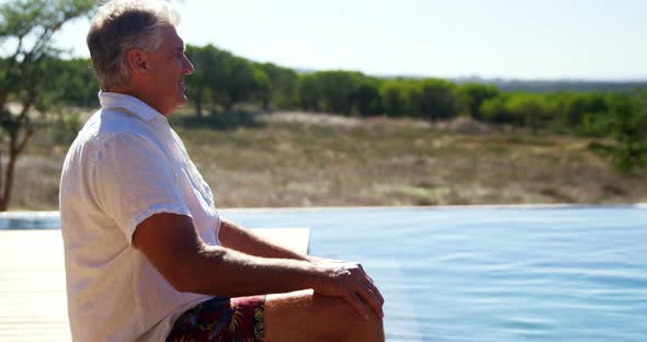 Thoughtful man sitting near pool side 4k