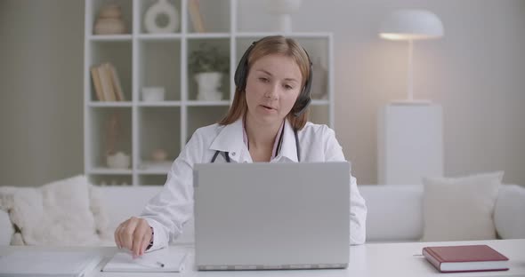 Online Appointment with Doctor, Female Therapist Is Asking Patient By Videocall on Laptop and