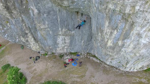 Aerial view of a man rock climbing up a mountain.