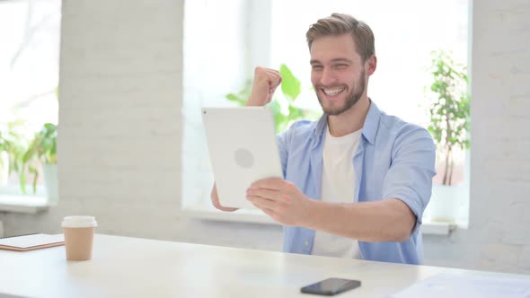 Successful Young Creative Man Celebrating on Tablet