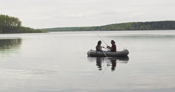 Young Fishermen on an Inflatable Boat on the Lake are Fishing