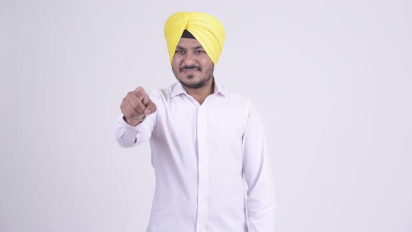Happy Bearded Indian Sikh Businessman Pointing To Camera