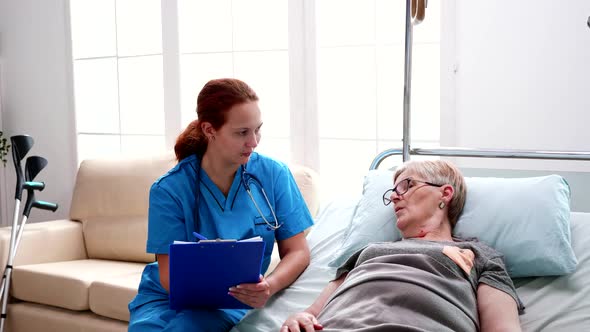 Female Nurse Taking Notes on Clipboard in Nursing Home