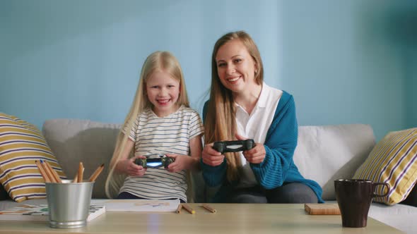 Happy Girl Plays Video Game with Her Mom