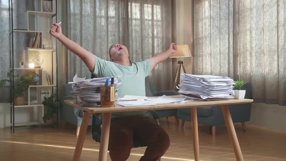 Happy Fat Asian Man Celebrating Finishing Working With Documents At The Office