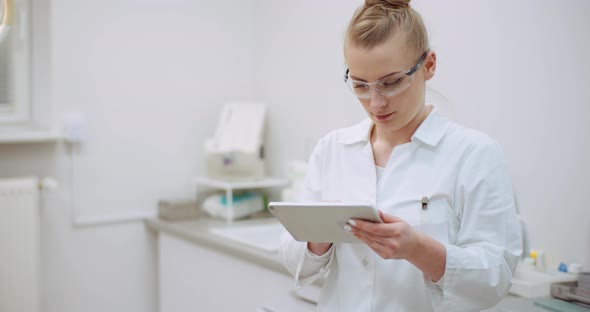 Female Doctor Using Digital Tablet at Dental Clinic