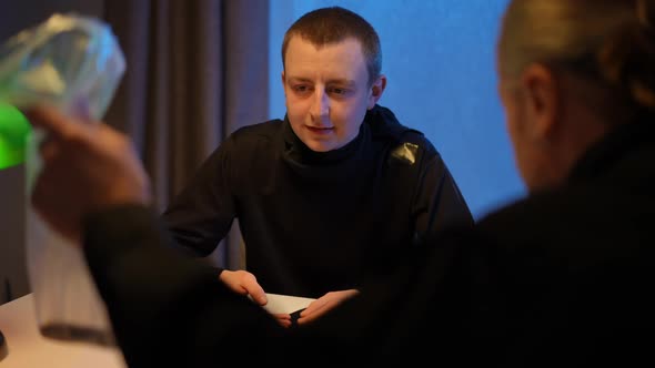 Portrait of Male Witness Talking Looking at Evidence in Policeman Hand
