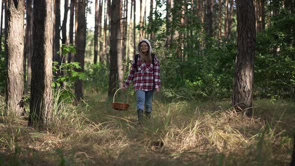 Wide Shot Smiling Young Caucasian Woman Walking with Wicker Basket in Spring Autumn Forest Searching