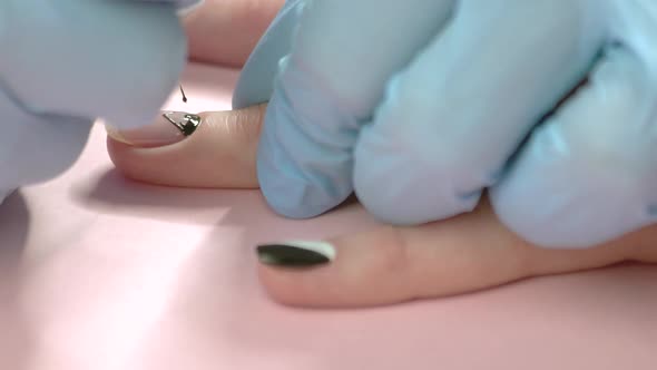 Manicurist Drawing on Nail Close Up.