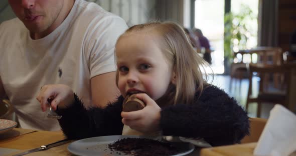 Little Girl With Dad In A Cafe Eating Dessert