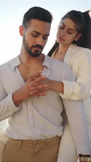 Hispanic Woman Kissing Boyfriend on Embankment in Sunshine