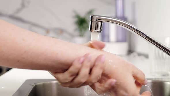 Woman Washing Hands at Kitchen