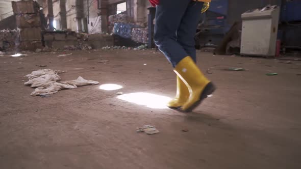 Unrecognizable Woman in Protective Working Clothes Rubber Gloves and Boots Walking By Waste