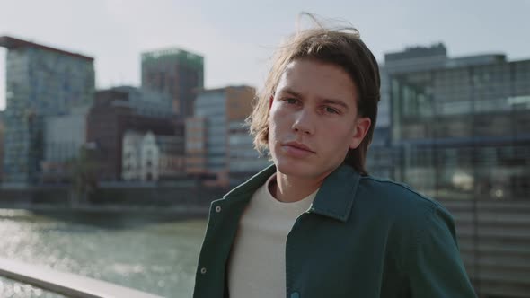 Confident Young Man Standing Outdoors Near City River