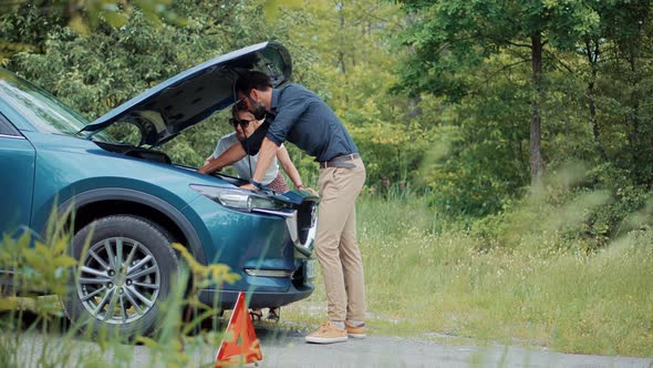 Frustrated Couple Repairing Accident Car. Sad Disappointed Woman On Broken Car. Vehicle Check Engine