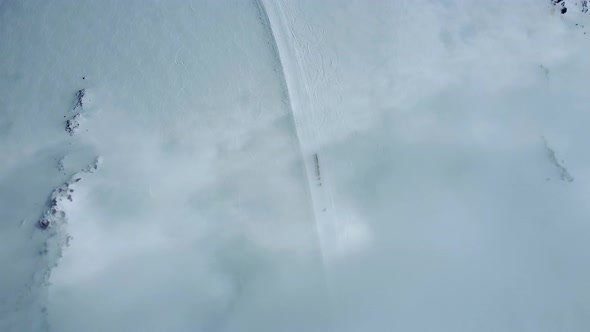 Aerial View Through Cloud on Snowed Mount Slope with Tourists Climbing at Top Traveling in Highland