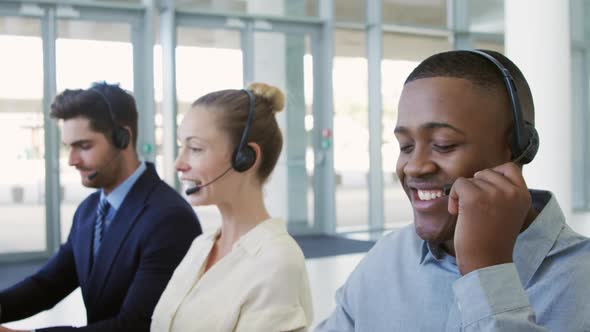 Young business people using headsets in a modern office