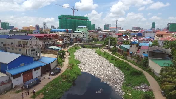 Aerial view of polluted river crossing city, Cambodia.