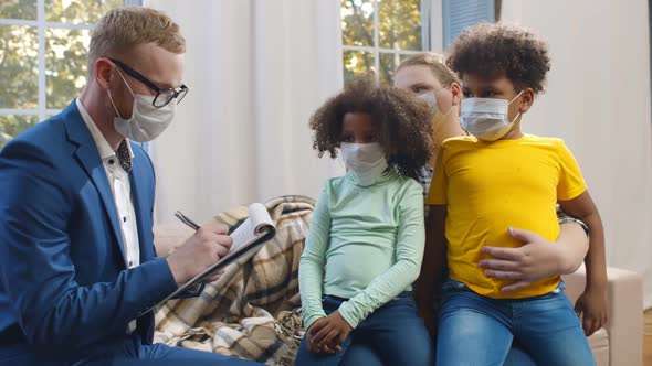 Young Social Worker in Safety Mask Visiting Foster Mother with Two Adopted Children