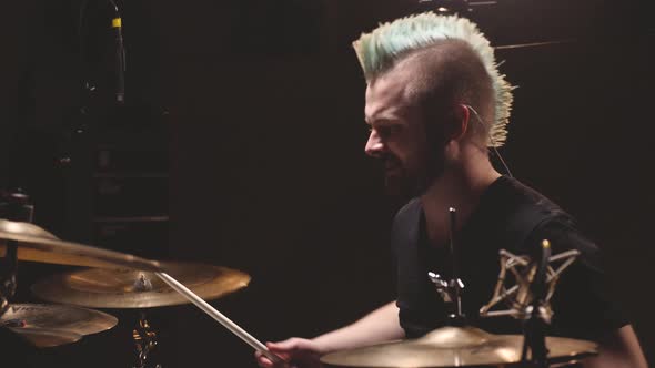 Drummer performing in a studio setting.