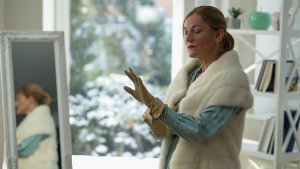 Medium Shot Portrait of Confident Elegant Middle Aged Caucasian Lady Putting on Glove