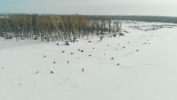 Skillful Fishermen Walk and Sit on Ice Fishing Bird Eye View