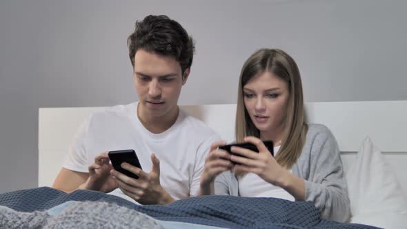 Couple Taking Selfie with Smartphone in Bed Photograph