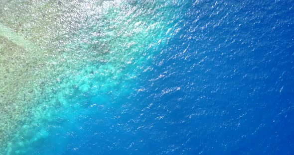 Tropical above abstract view of a white sandy paradise beach and aqua turquoise water background in 