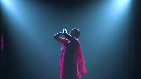 Silhouette a Young Girl Dancer in a Red Sari. Indian Folk Dance. Shot in a Dark Studio with Smoke