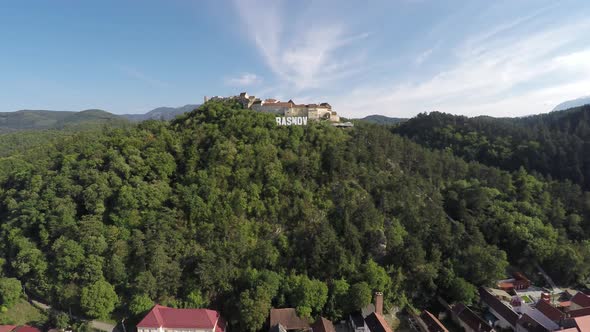 Aerial of Rasnov Citadel and a forested hill