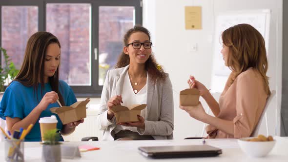 Happy Businesswomen Eating Takeaway Food at Office