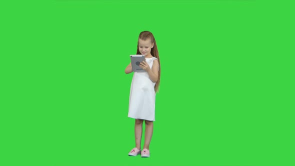 Small Girl with Tablet Computer on a Green Screen, Chroma Key